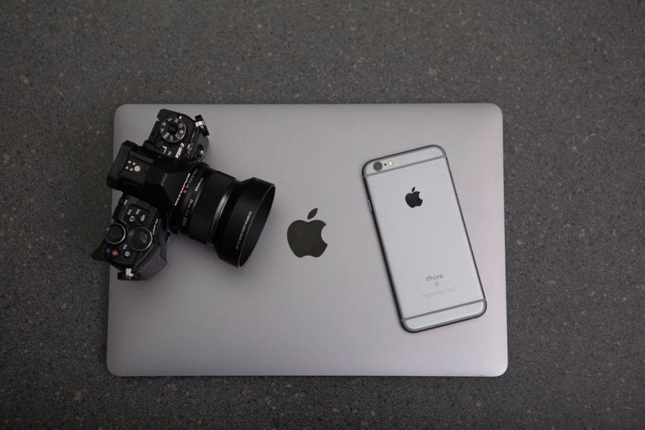 Still life editorial tech: MacBook com um ficheiro .dmg no Finder e uma seta automática estilizada a apontar para a pasta Aplicações, fundo limpo, sem pessoas nem mãos